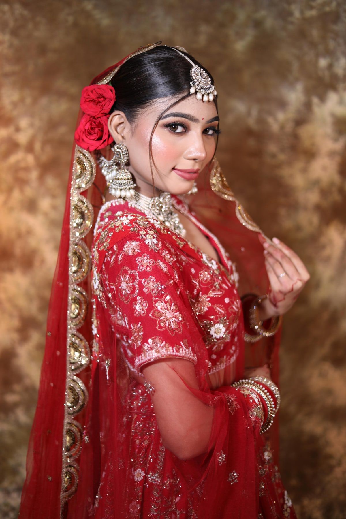Bridal hairstyle with red rose bun and dupatta setting
