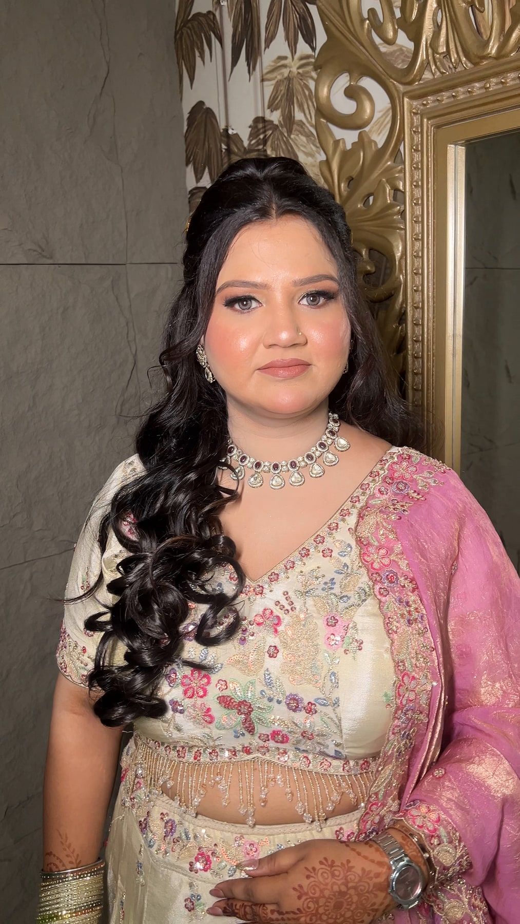 Engagement makeup with soft curls, pastel pink lehenga and diamond choker