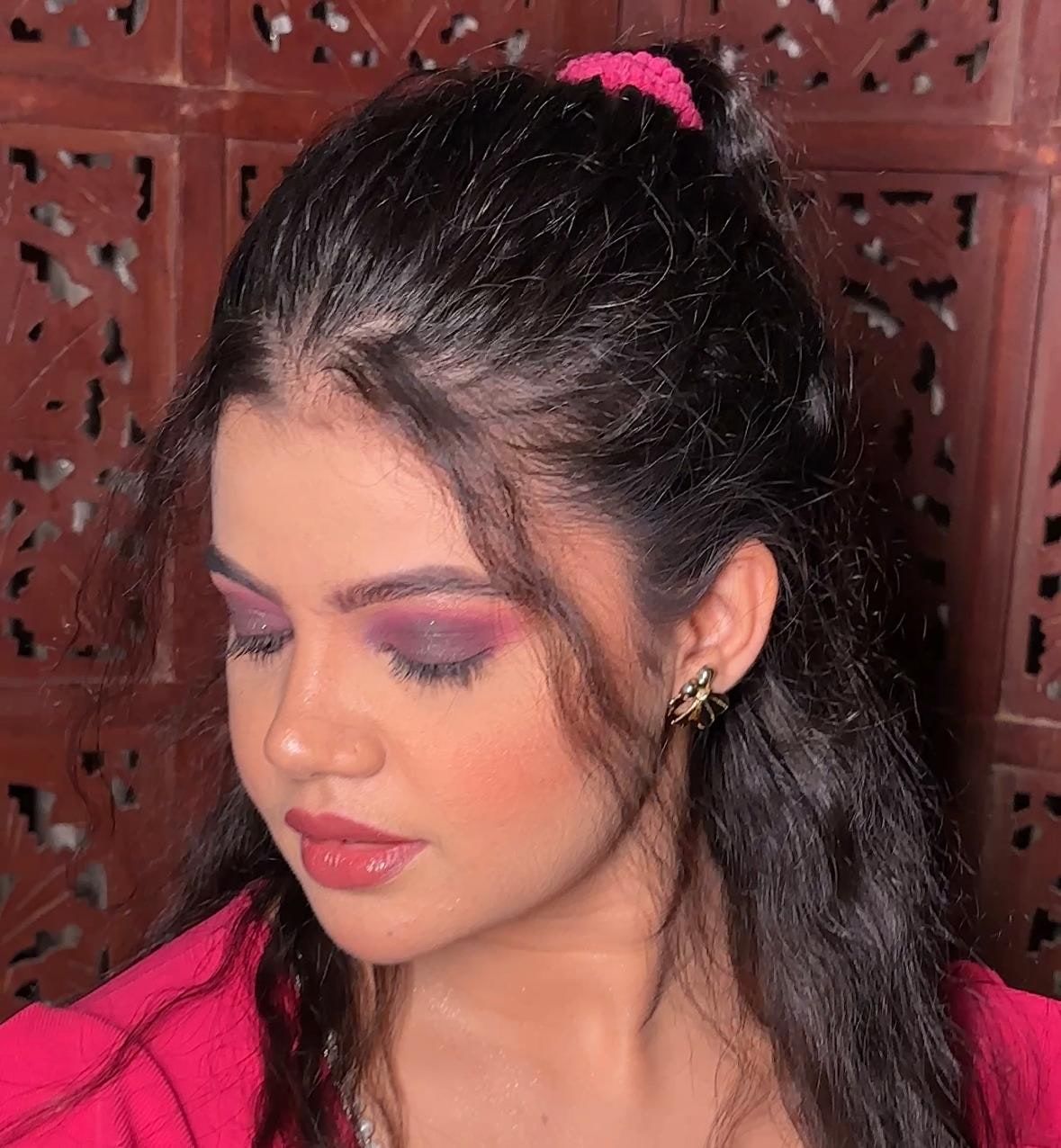 Close-up of pink and purple party eye makeup with soft waves